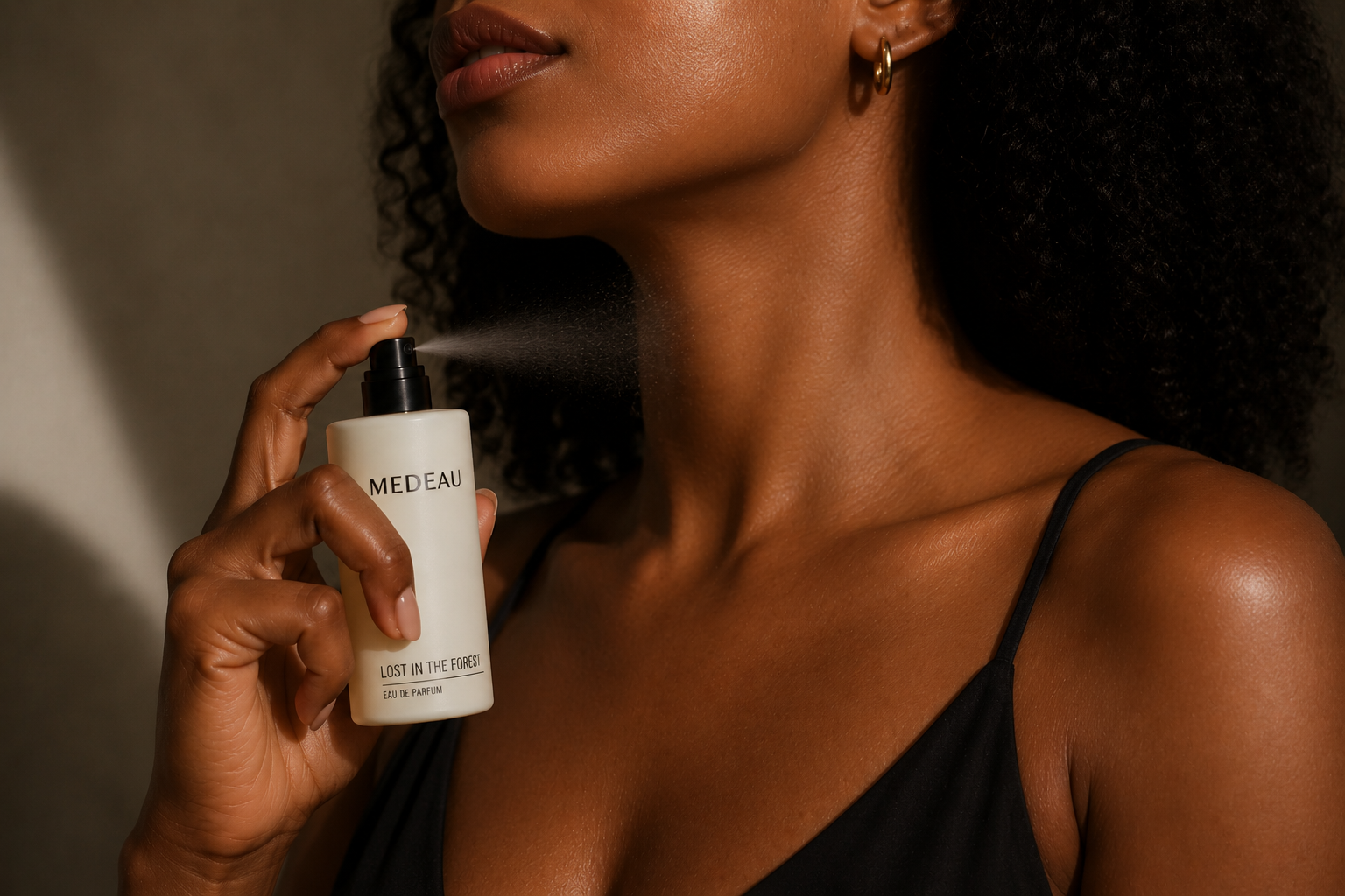 A woman spraying Medeau Lost In The Forest eau de parfum on her neck